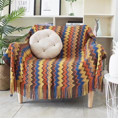 a living room with a colorful couch and potted plants