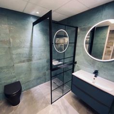 a bathroom with a toilet, sink and mirror in it's center wall area