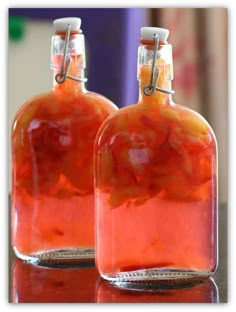 two bottles filled with liquid sitting on top of a table