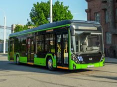 a green bus is driving down the street