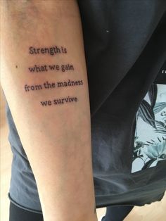 a person with a tattoo saying strength is what we gain from the madness we survive