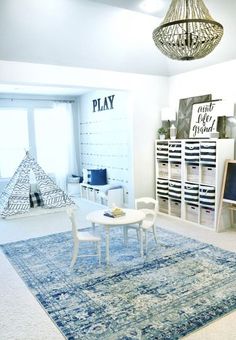 a living room filled with furniture and a blue rug on top of a wooden floor