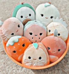 a bowl filled with stuffed animals sitting on top of a carpet