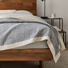 a bed with a wooden headboard and night stand next to it in a bedroom