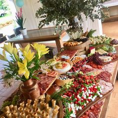 a table filled with lots of food and flowers on top of each other in front of a potted plant