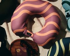 an assortment of shoes and accessories laid out on a bed with a pink ring shaped pillow