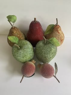 there are some fruit on the table and one is green with gold leafy leaves