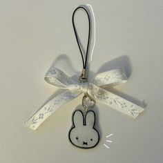 an ornament with a rabbit on it's side and a ribbon around the neck