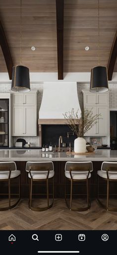 a kitchen with an island, stove and dining table in the center is surrounded by white chairs