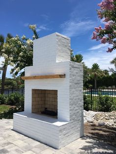 a white brick fireplace sitting on top of a patio