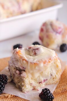 a close up of some food on a napkin with berries and cake in the background