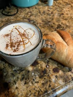 there is a cup of coffee and some bread on the counter