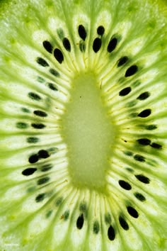 the inside of a kiwi fruit with black dots on it's center piece