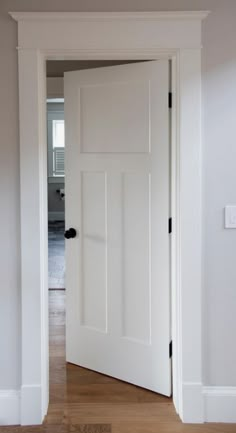 an open white door in the middle of a room