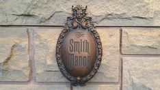 a sign that is on the side of a brick wall with a plaque reading,'the smith manor '