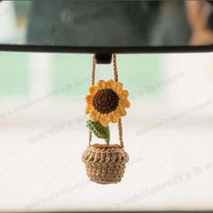 a sunflower is hanging from a car's rear view mirror as it sits on a rope