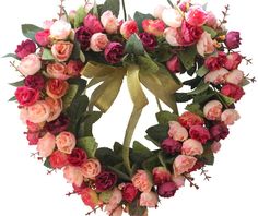 a heart shaped wreath with pink and red flowers