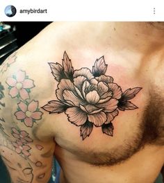 a man's chest with a flower tattoo on his left side and the upper half of his stomach