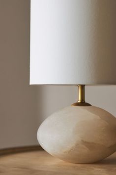 a white lamp sitting on top of a wooden table