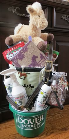 a teddy bear sitting on top of a bucket filled with cleaning products and personal care items