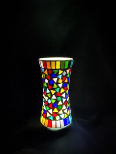 a multicolored vase sitting in the dark