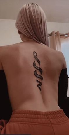 a woman with a snake tattoo on her back