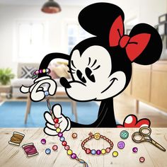 a minnie mouse cutout with beads and scissors on a table in front of a living room