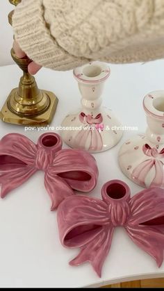 pink bows and candlesticks are on a table