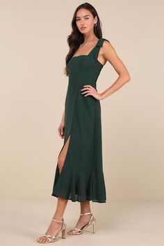 a woman wearing a green dress with one side slited and the other side split open