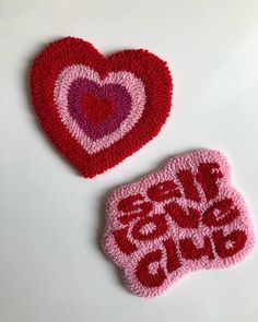 two crocheted hearts with the words love is in the air written on them