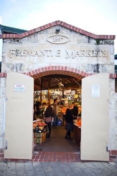 people are walking through the entrance to a market