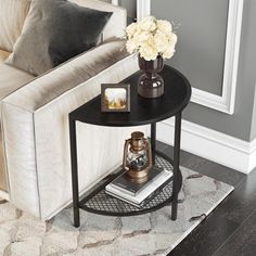 a living room with a white couch and a black end table on top of a rug