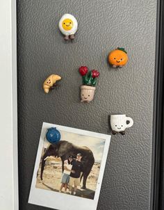 magnets on the back of a refrigerator with pictures and other items attached to it