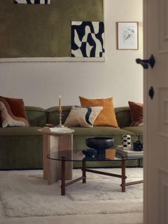 a living room filled with furniture next to a painting on the wall above a coffee table