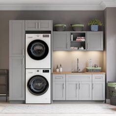 a washer and dryer sitting in a room with white cupboards on the wall