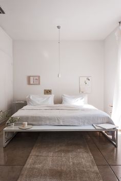 a white bed sitting on top of a wooden floor