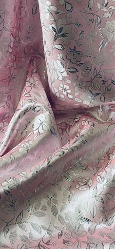 a pink and silver fabric with flowers on it