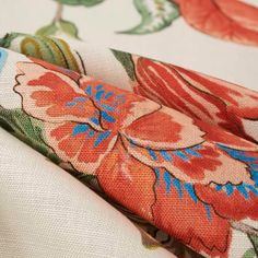 an orange flowered fabric with blue and pink flowers on it's side, close up