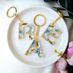 a white plate topped with two pieces of glass and gold keychain shaped like letters