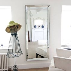 a living room with a chair and a large mirror on the wall next to it