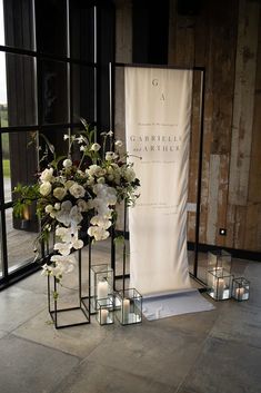 flowers and candles are on display in front of a sign