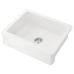 a white kitchen sink with a drain in the center and an overflowing faucet