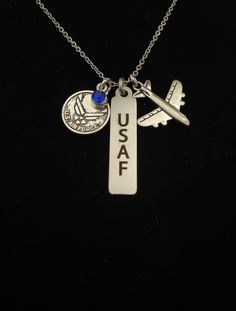 "For an Airman, wife or mom.  They would be proud to wear this necklace. It is the perfect gift for anyone who knows the commitment wrapped up in those four letters. This silver tone necklace has charms depicting the Air Force wings emblem with a blue gem, a laser engraved \"USAF\" (United States Air Force) stainless steel charm and an airplane. * 18\" Stainless Steel chain * Lobster claw closure * Perfect for completion of BCT,  or for the loved one of an airman. * This piece comes packaged in a gift box suitable for presentation" Personalized Blue Round Pendant Jewelry, United States Air Force, Blue Gems, Steel Chain, Be Proud, Stainless Steel Chain, Charm Necklaces, Laser Engraved, Lobster Claw