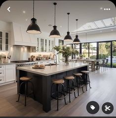 a large kitchen with an island in the middle and lots of stools around it