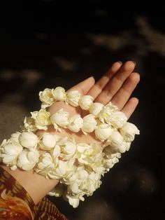 a woman's hand with white flowers on it