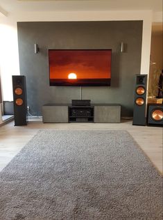 a living room with speakers and a flat screen tv