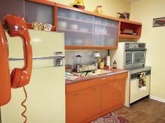 a kitchen with orange cabinets and an old fashioned phone on the wall above the sink