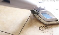 a person using a steam mop on a tile floor with dirt all over it