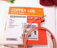 the copper coil is sitting on top of some paper and other items next to it