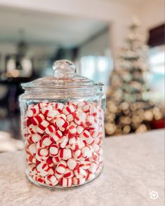 a glass jar filled with red and white candy canes